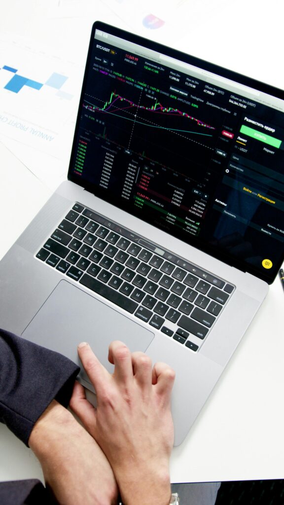 Professional analyzing stock market graphs on a laptop, showcasing investment insights.